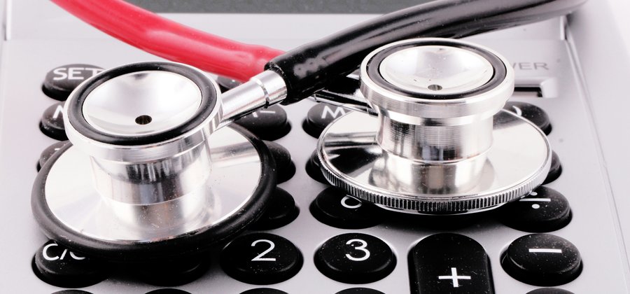 Stethoscope resting on a calculator, representing healthcare billing expertise